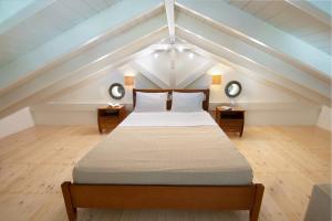 a attic bedroom with a bed and two night stands at West Forest House in Magaziá