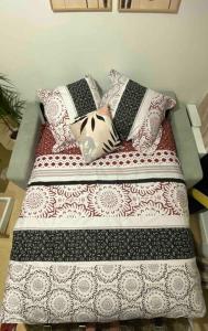 uma cama com várias almofadas em cima em Appartement charmant proche Paris em Ivry-sur-Seine