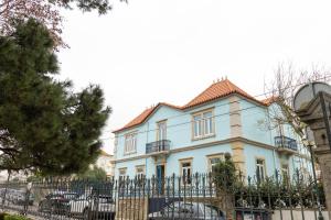 a blue house with a fence in front of it at Surf & Sea Suites in Parede