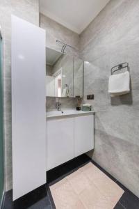 a white bathroom with a sink and a mirror at Brand New 2 Bedroom Modern Flat in Bodrum Center in Bodrum City