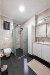 uma casa de banho com um chuveiro, um WC e um lavatório. em Brand New 2 Bedroom Modern Flat in Bodrum Center em Bodrum City