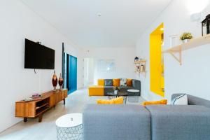 sala de estar con sofá y TV en Hostel Surf & Sea, en Parede