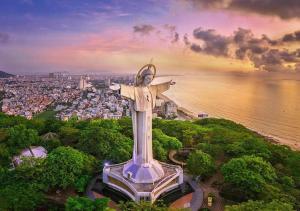 a statue of christ the redeemer in front of a city at The Song VT Beach Apartment in Vung Tau