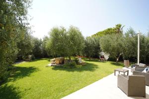 a garden with couches and chairs in the grass at B&B MadaM in Faggiano