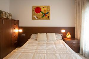 1 dormitorio con 1 cama y una foto en la pared en Can Vilardell, en Ripoll