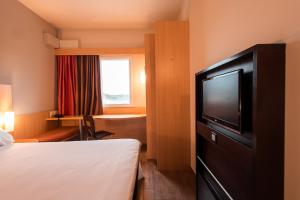 a hotel room with a bed and a flat screen tv at ibis Presidente Prudente Manoel Goulart in Presidente Prudente