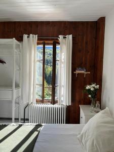 a bedroom with a bed and a window at Hotel Au Bon Accueil in Les Deux Alpes