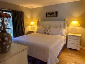 1 dormitorio con 1 cama blanca con 2 lámparas y una ventana en 68 Inlet Cove, en Kiawah Island