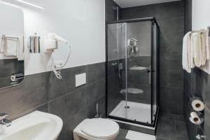 e bagno con doccia, servizi igienici e lavandino. di Hotel im Hegen a Oststeinbek