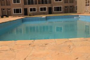 a pool of blue water in front of a building at 3 bedroom furnished apartment at Kings Square in Eldoret