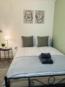 - un lit dans une chambre avec 2 photos sur le mur dans l'établissement Willesden J Guest Home 4, à Londres