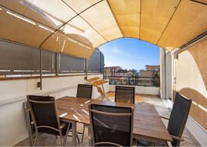 d'un balcon avec vue doté de tables et de chaises en bois. dans l'établissement MargheritaLigure, à Ospedaletti