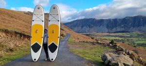 two surfboards are standing on a road at Wastwater Cottage for Scafell and Wasdale in Seascale