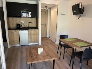 a kitchen and dining room with a table and chairs at Fiori di Cala Rossa résidence hôtelière in Lecci