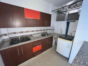 a kitchen with a stove and a sink and a refrigerator at Apartamento en Alameda Cali in Cali