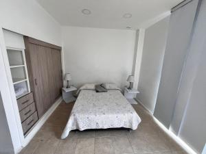 a bedroom with a bed and two night stands at Apartamento en Alameda Cali in Cali