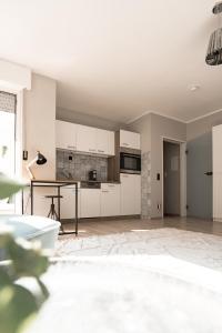 a kitchen with white cabinets and a table at Buer City Apartment mit Balkon in Gelsenkirchen