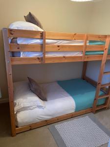 two bunk beds in a room with a bed at 2 Fernleigh Villas in Perranporth