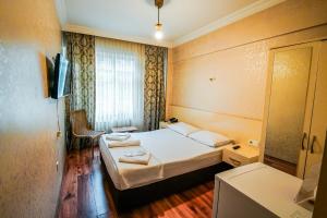 Una habitación de hotel con dos camas y un espejo. en SAHRA OTEL, en Estambul 11 fotos más
