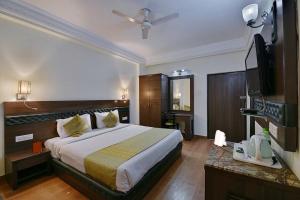 a hotel room with a bed and a flat screen tv at Hotel Empire Regency in Jaipur