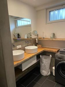 a bathroom with two sinks and a washing machine at Joli logement 6 à 8 pers avec terrasse La Cigale in Orbey