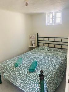 1 dormitorio con 1 cama con edredón verde en Beach Tree House en Cortegaça