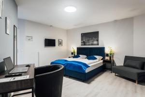 1 dormitorio con cama, escritorio y silla en Hotel im Hegen en Oststeinbek