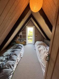 a attic room with two beds and a window at Charmerende sommerhus in Ringkøbing