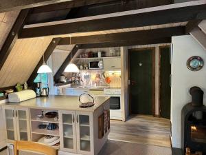 a kitchen with white cabinets and a stove top oven at Charmerende sommerhus in Ringkøbing