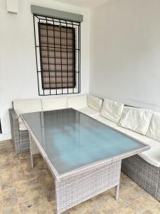 Suite Bosque de la Alborada B في غواياكيل: طاولة زجاجية وأريكة في الغرفة