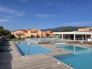 una grande piscina con acqua blu in un resort di Résidence hôtelière les hameaux de saint cyprien appartement 25 M2 1 chambre a Lecci