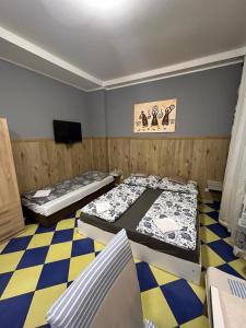 a room with two beds and a flat screen tv at Apartments Manhattan in Teplice