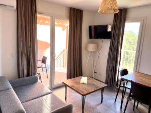 salon z kanapą i stołem w obiekcie Résidence hôtelière les hameaux de saint cyprien 25 M2 w mieście Lecci +37 zdjęć
