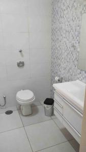 a white bathroom with a toilet and a sink at Espaço Geraldo Meirelles in Casa Branca