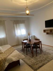 - une chambre avec une table à manger et un lit dans l'établissement Hostel Apart, à Dar el Beïda
