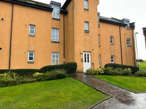 a large brick building with a lawn in front of it at Spacious Modern Apartment in St. Andrews
