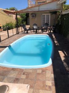 una piscina azul en un patio con sillas en La Comarca Aparts Alojamiento en Colón