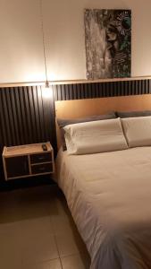 um quarto com uma cama com uma mesa de cabeceira ao lado em La Comarca Aparts Alojamiento em Colón