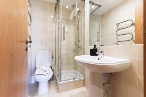 a bathroom with a toilet and a sink and a shower at Telheiras Premium by Homing in Lisbon +24 photos