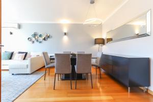 a dining room and living room with a table and chairs at Telheiras Premium by Homing in Lisbon