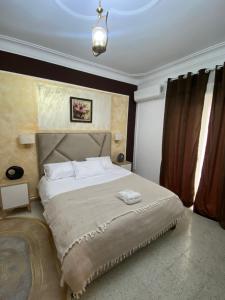 1 dormitorio con 1 cama grande con almohadas blancas en Hostel Apart, en Dar el Beïda