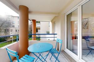 d'un balcon avec une table bleue et des chaises. dans l'établissement My Cozy Flat - Côté Jardin - Parking - Terrasse, à Toulouse