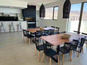 una cocina con mesas y sillas de madera en una habitación en Hermoso departamento ful amueblado nivel ejecutivo en Antofagasta