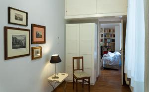 um quarto com uma cadeira, uma mesa e uma estante de livros em Gallery Apartment, Near The Vatican em Roma