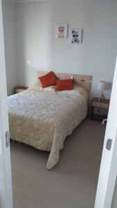 Un dormitorio con una cama con almohadas rojas. en Hermoso departamento ful amueblado nivel ejecutivo en Antofagasta