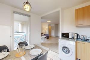 a kitchen and dining room with a table and a washing machine at My Cozy Flat - Côté Jardin - Parking - Terrasse in Toulouse