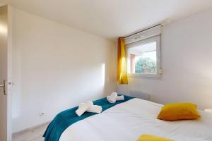 - une chambre avec un lit et 2 serviettes dans l'établissement My Cozy Flat - Côté Jardin - Parking - Terrasse, à Toulouse