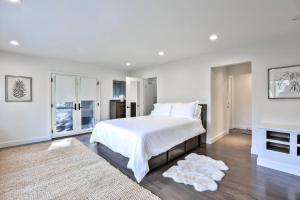 een witte slaapkamer met een groot bed en een open haard bij Stunning Executive Retreat 5b/4ba —Entire Home in Portola Valley