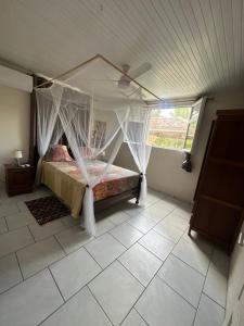 a bedroom with a canopy bed in a room at Kay Jean Au Diamant in Le Diamant