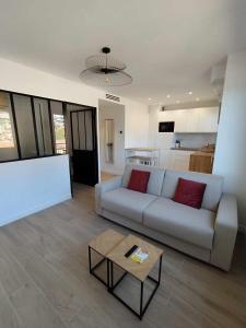 un soggiorno con divano e tavolo di Appartement moderne refait à neuf - 4 couchages - MENTON a Mentone